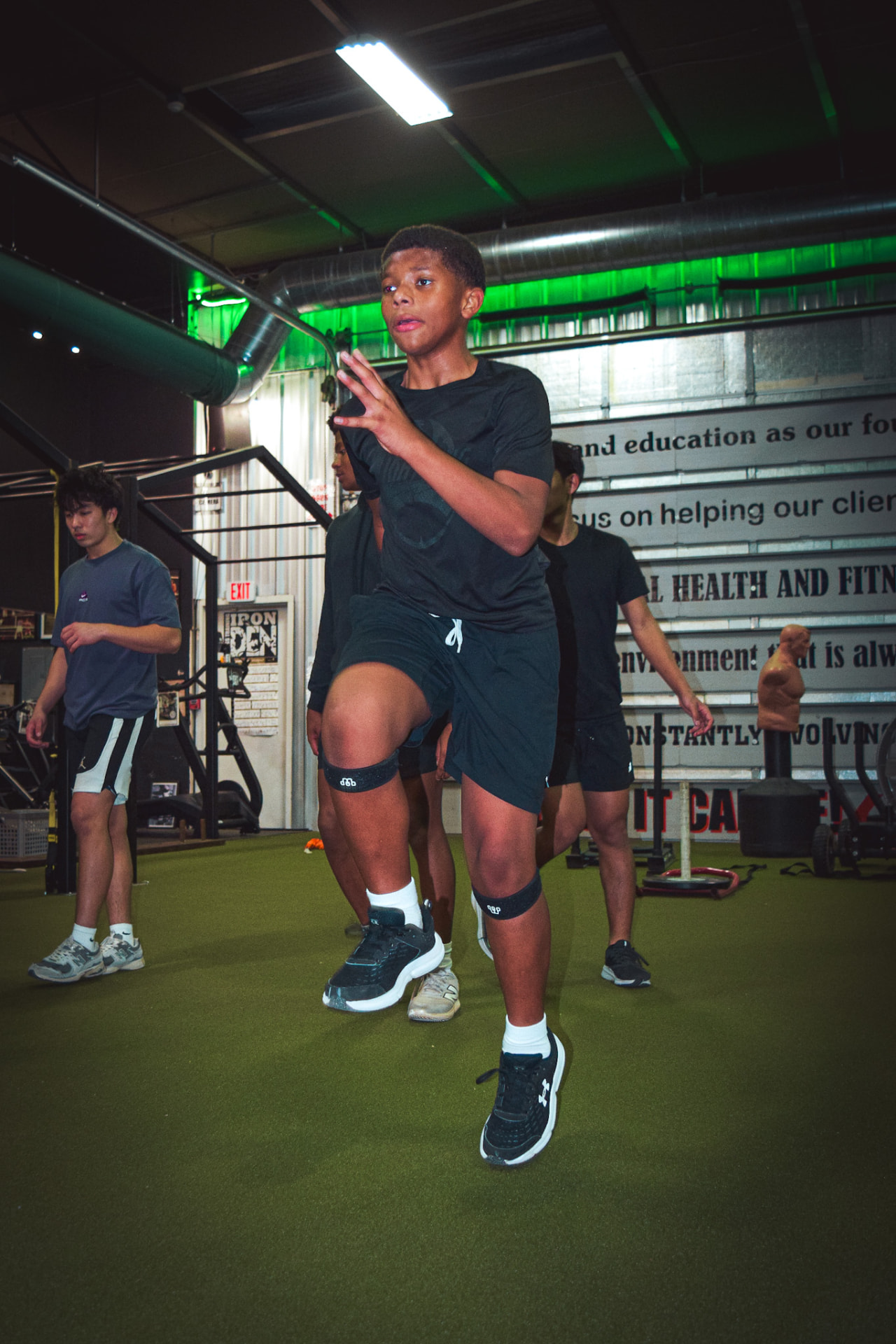 DUB Athletic athlete driving through high-knee speed drills in a training facility